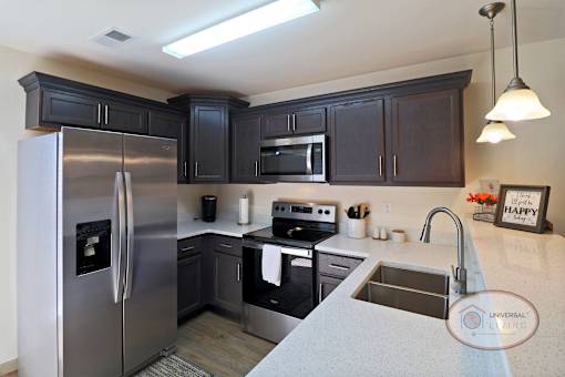 A kitchen with dark cabinets and stainless steel appliances.