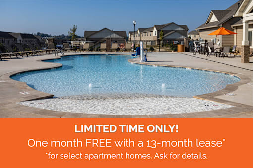 A pool surrounded by apartment buildings with a sign offering a free month with a lease.