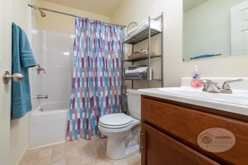 A bathroom with a shower and a toilet and a sink.