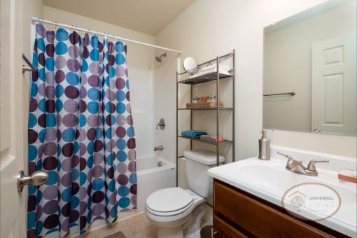 a bathroom with a shower curtain and a toilet and sink