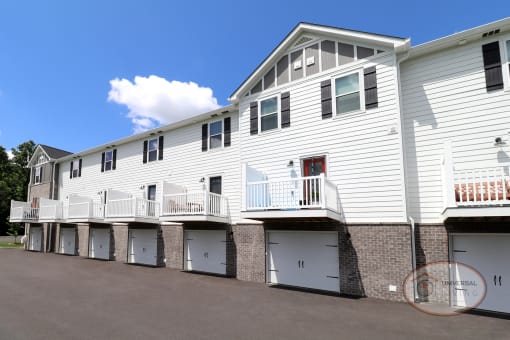 An up-close photo of the white garages and balconies on the 2 and 3 bedroom apartment homes.