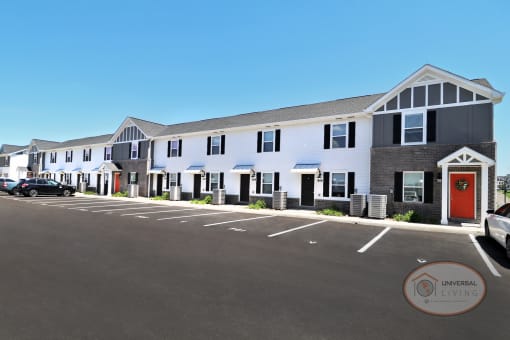 Two and Three Bedroom Apartment Homes with white and grey exterior and orange doors.