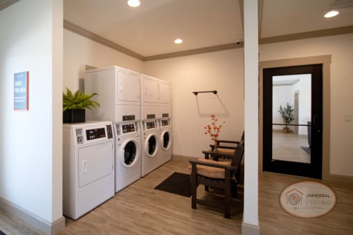Laundry center with washing machines, dryers, and tables.