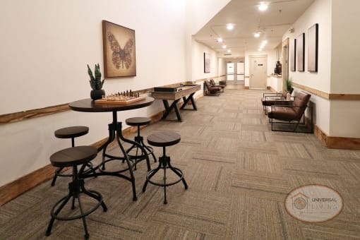 A long hallway full of lounge seating, tables, and games.