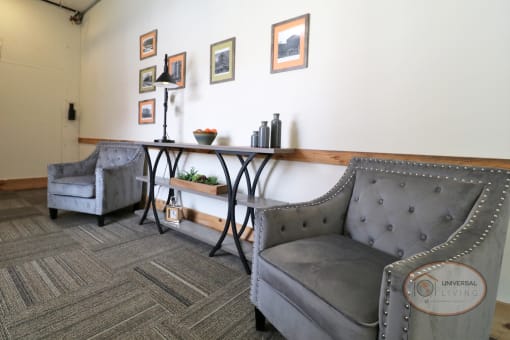 A sitting area on the second floor with lounge chairs and artwork on the walls.
