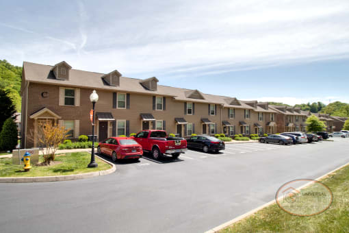a parking lot with cars in front of an apartment building