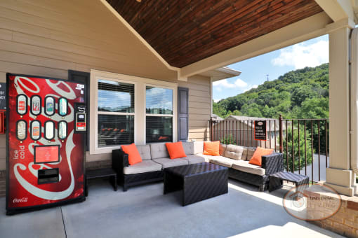 a covered porch with a coke machine and couches