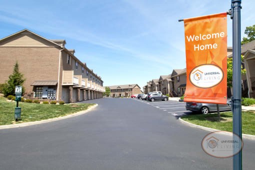 an orange welcome home banner on the side of a street