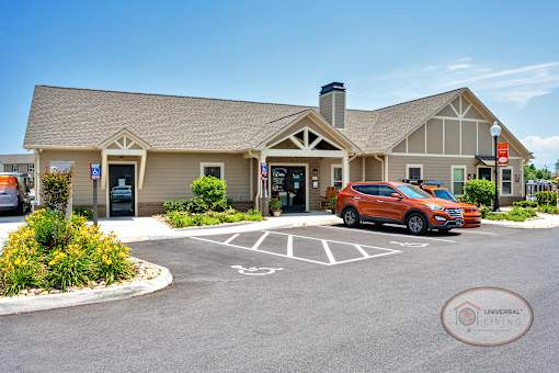 The exterior of a tan clubhouse with parking.