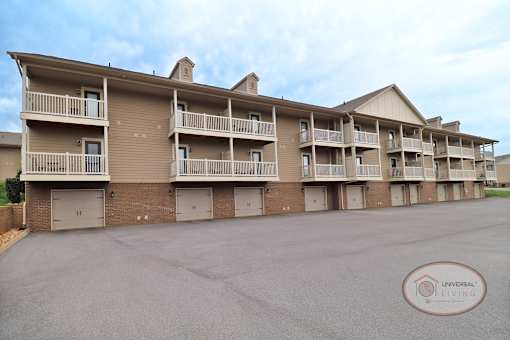 The rear of a one bedroom stacked apartment home with balconies and patios.