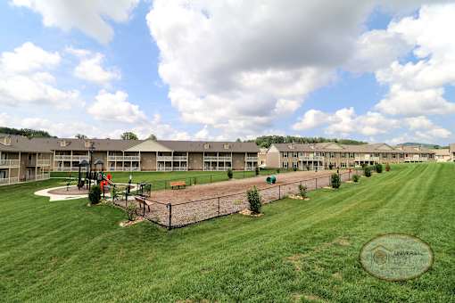 An overview of the property with the playground and dog park in the forefront, and apartment homes in the background.