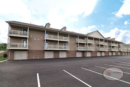 The rear of a one bedroom stacked apartment home with balconies and patios.