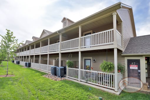 The rear of a one bedroom stacked apartment home with balconies and patios.