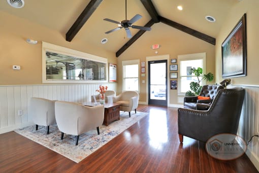 The clubhouse lounge with tables and seating, and a door leading to the pool area.