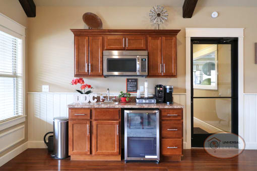 A coffee bar with mini fridge and microwave.