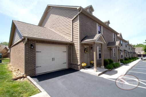 A garage attached to the end of a row of tan apartments.