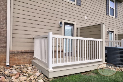 A fenced in patio with glass door and privacy wall.