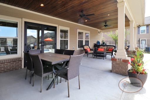 Poolside patio with flat screen TV, table with chairs, and lounge seating.