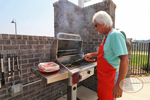 a man in an apron preparing food on a barbecue grill