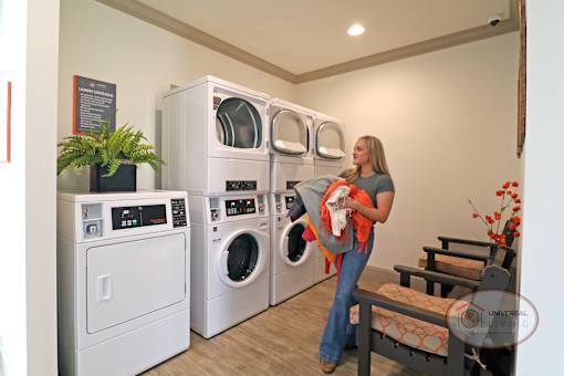 a woman holding a baby in a laundry room with washing machines