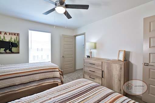 A bedroom with two twin beds, a large window, and walk in closet.