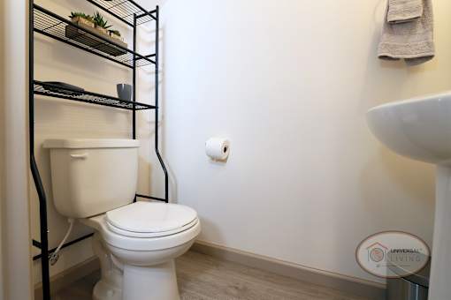 A half-bathroom with white walls, toilet, and sink.