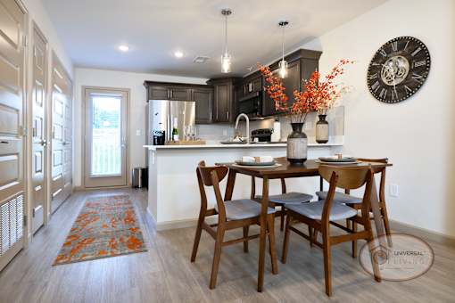 A kitchen with a dining table and chairs.
