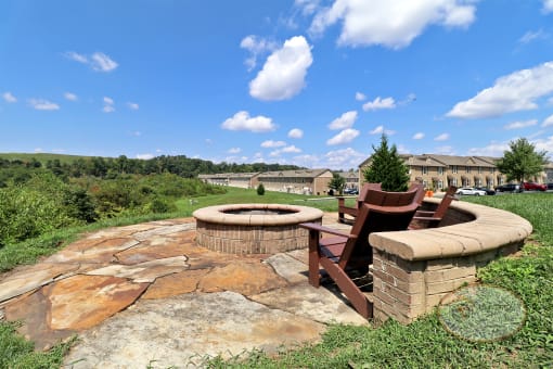 A fire pit with lounge chairs overlooking the mountains.