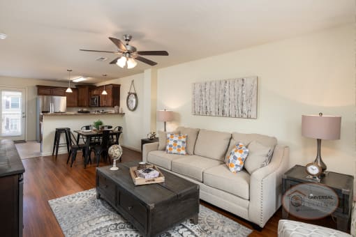 A spacious living room with a couch and a ceiling fan.