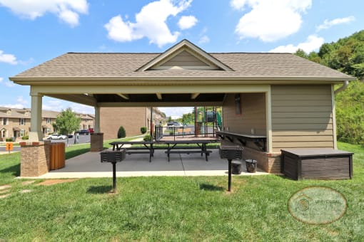 A covered picnic and grill area with picnic tables.