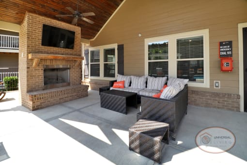 The poolside patio, complete with fireplace, flat screen TV, lounge seating, and a ceiling fan.