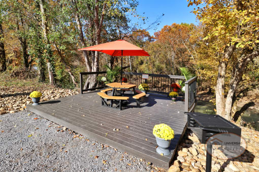 A picnic table on a deck overlooking the river.