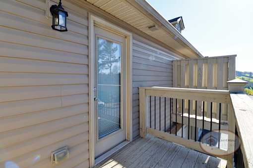 A balcony with glass door overlooking the property.