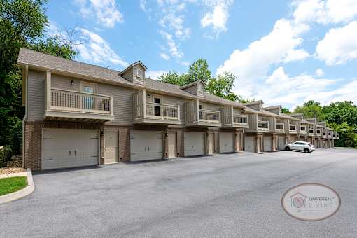 A tan row of apartments with balconies and drive-under garages.