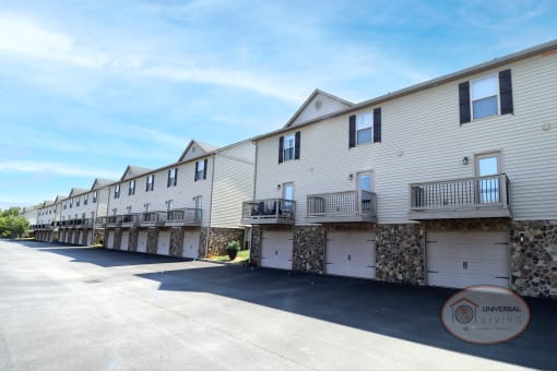 a row of white houses with balconies and a parking lot