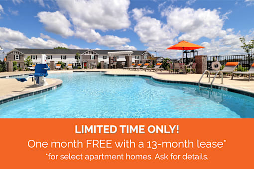 A pool surrounded by chairs and umbrellas with a sign offering a free month with a 13-month lease for select apartment homes.