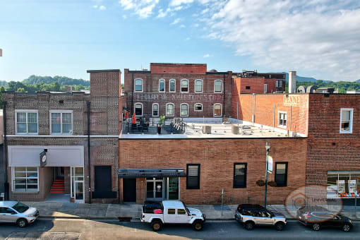 A view of the Front of The Henry on Main, a historic brick building in downtown Johnson City, TN,  with a visible rooftop patio.