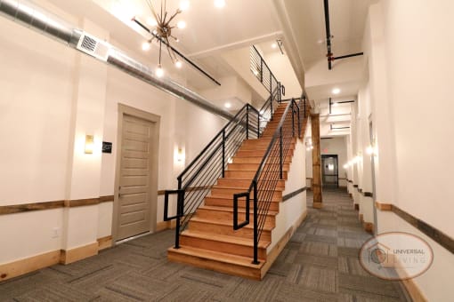A wooden staircase in a hallway of apartment homes.