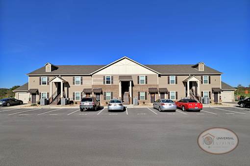 a large apartment building with cars parked in front of it