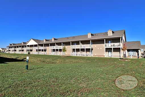 a large apartment building on a green field