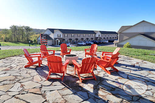 a group of red chairs sitting around a fire pit