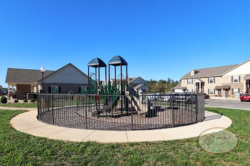 a playground with a swing set in front of a house