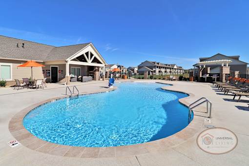 a resort style swimming pool with a building in the background