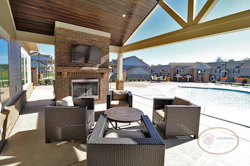 a patio with chairs and a fireplace next to a pool