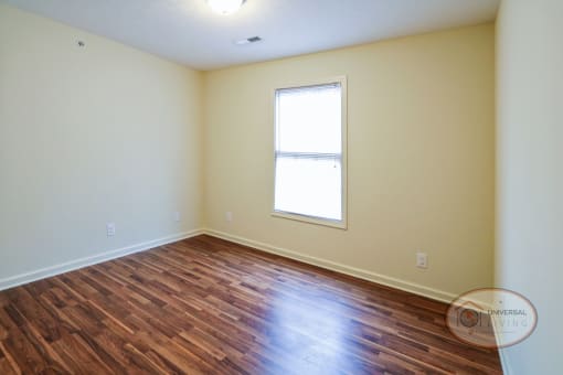 a bedroom with hardwood vinyl flooring.
