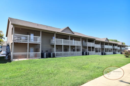 The rear of a one bedroom stacked apartment home with balconies and patios.