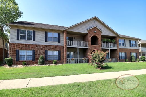 The back of a two story apartment home with balconies and patios.
