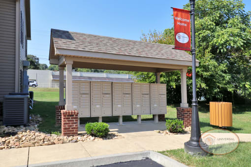The mail center located outside near a "Welcome Home" banner.