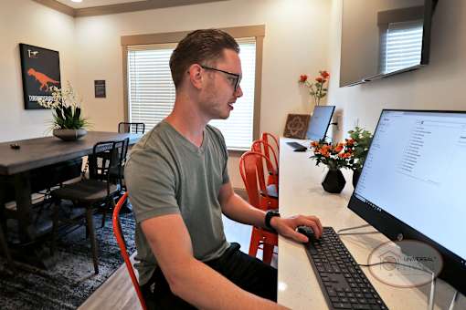 A man sitting at a computer in the business center doing work.