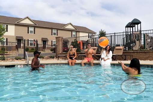 A group of people are enjoying a day in a pool.